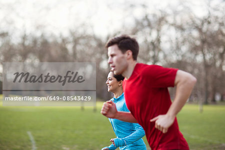 Young man and woman running together in park Young man and woman running together in park