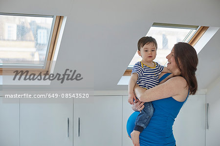 Side view of pregnant mother holding baby boy