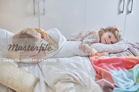 Girls in pyjamas day-dreaming in bed