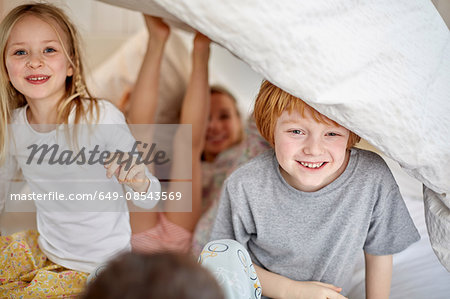 Children having fun playing in bed