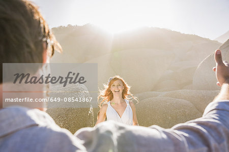 View over mans shoulder of red haired woman smiling
