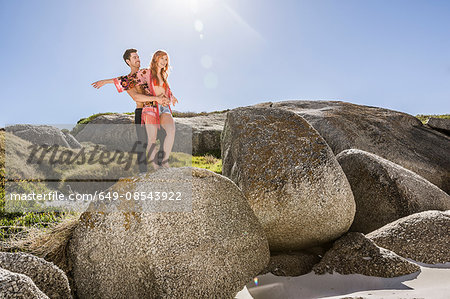 Couple outdoors, standing on rock, looking at view