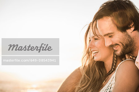 Mid adult couple on beach watching sunset, Cape Town, South Africa