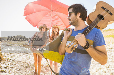 Mid adult women carrying  beach umbrella at beach, Cape Town, South Africa