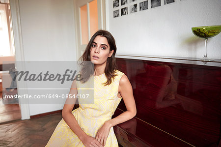 Portrait of stylish young woman in front of piano