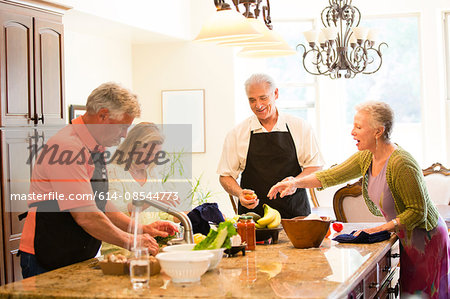 Group of seniors preparing meal in kitchen