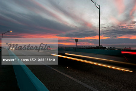 Light trails from traffic on highway at sunset