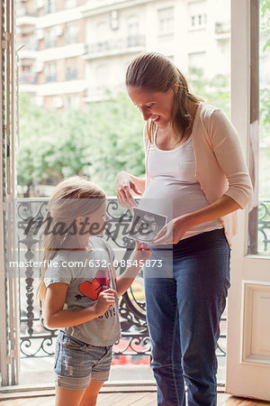 Mother preparing daughter for arrival of her new sibling