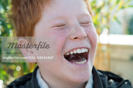 Boy laughing with eyes closed, portrait