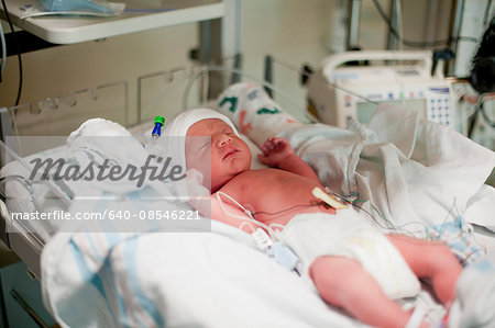 Newborn baby laying in bassinet in hospital