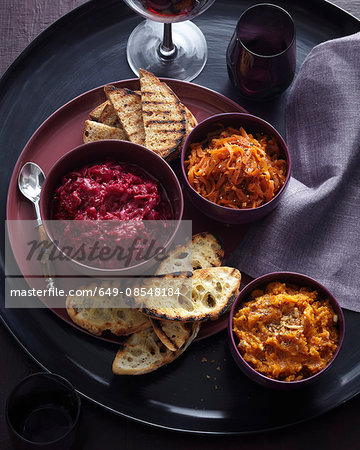 Overhead view of fresh bowls of winter dips and toasted breads
