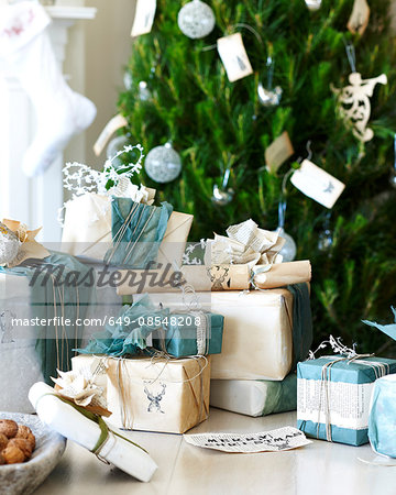 Handmade christmas gift wrapping and christmas crackers in front of christmas tree