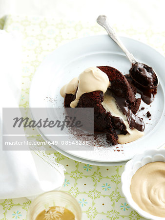 High angle view of chocolate fondant with gooey centre with cream on plate