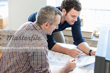 High angle view of men in office discussing paperwork