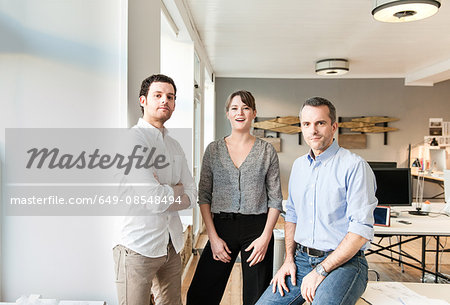 Colleagues in office looking at camera smiling