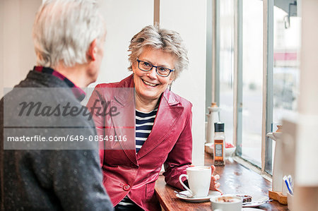 Senior couple chatting in cafe window seat