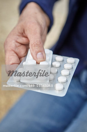 Womans hand holding blister packs of pills