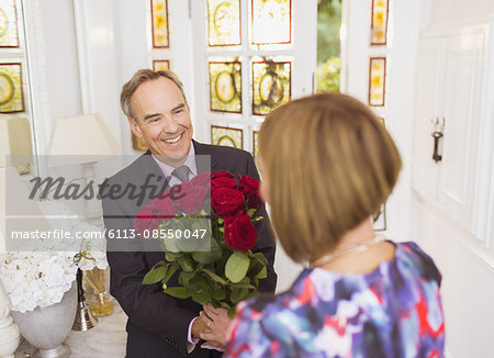 Mature man giving rose bouquet to wife