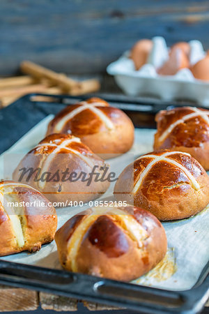 Easter English buns on a baking sheet.