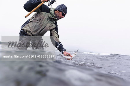 Man fishing on coastline