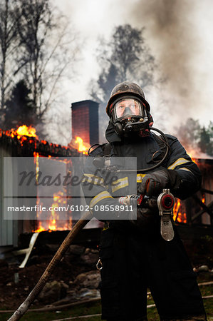 Fire fighter in front of burning buildings