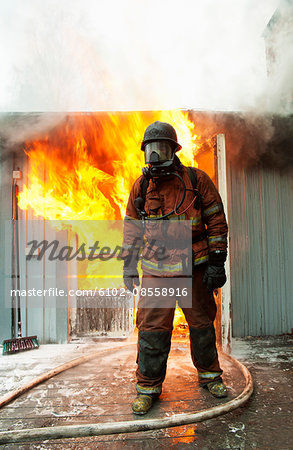 Fire fighter in front of burning buildings