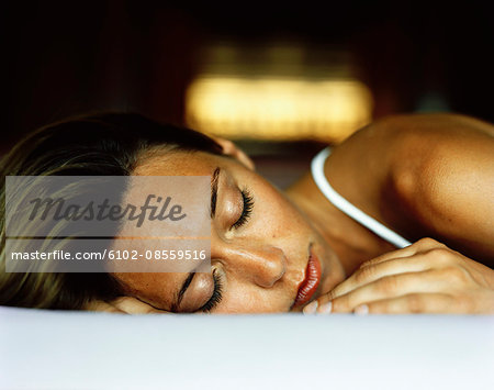 A sleeping woman lying on a bed, Thailand.