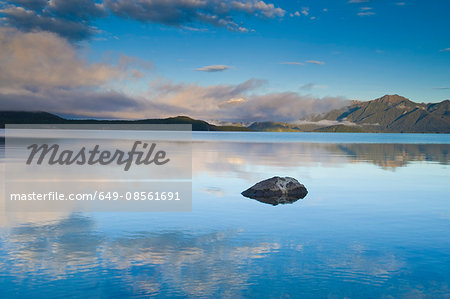 Rural mountains reflected in still lake