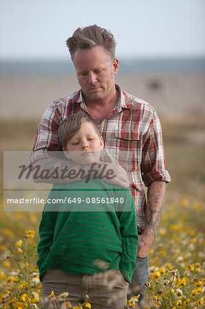 Man hugging son in field of flowers