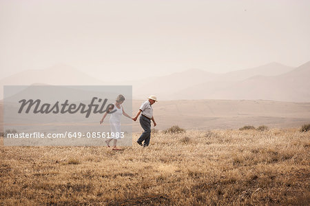 Older couple walking in rural field