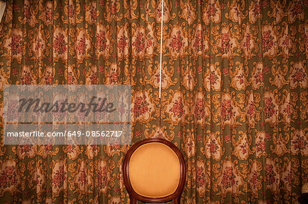 Chair in front of patterned curtains