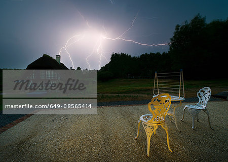 Lighting in night sky behind house