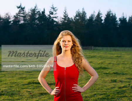 Portrait of confident young woman in field landscape