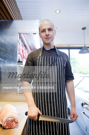 Portrait of butcher holding butchers knife in butchers shop