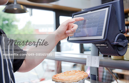 Cropped shot of butcher weighing pie in butchers shop