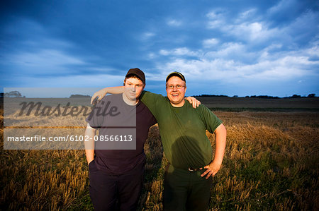 Two farmers standing in field