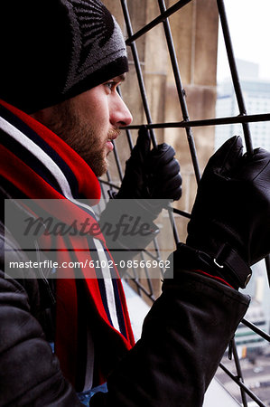 Man looking out through bars, Poland.