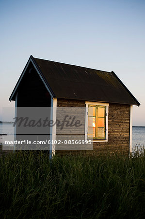 A small cottage by the sea at sunset, Sweden.