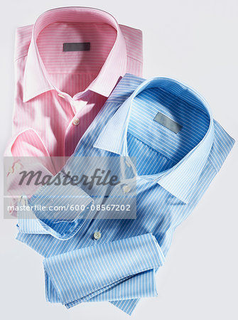 Two shirts, pink and blue, on white background, studio shot