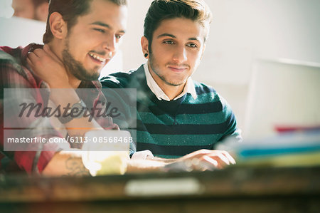 Young creative businessmen working at laptop in office