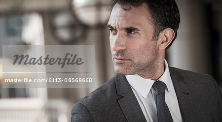 Close up pensive corporate businessman looking away Close up pensive corporate businessman looking away