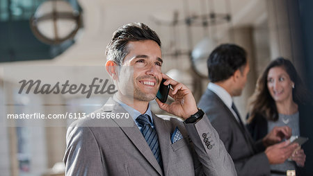 Smiling corporate businessman talking on cell phone