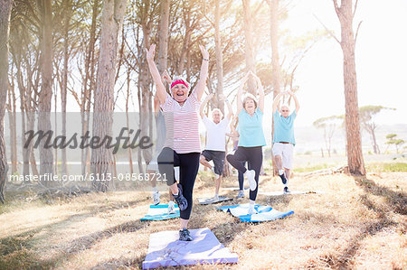 Senior adults practicing yoga in sunny park