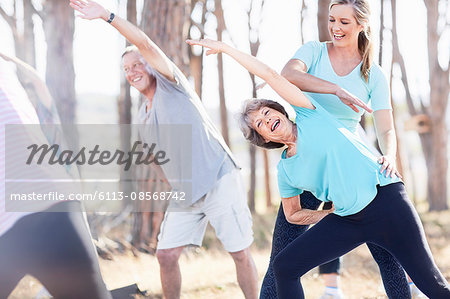 Yoga instructor guiding senior woman in park Yoga instructor guiding senior woman in park
