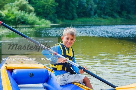 Active happy child having fun adventurous experience kayaking on the river on a sunny day during summer vacation