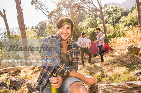 Portrait of male camper with friends in forest, Deer Park, Cape Town, South Africa