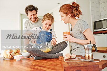 Girl whisking eggs on kitchen counter for parents breakfast