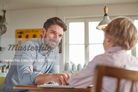 Father and son working in home office