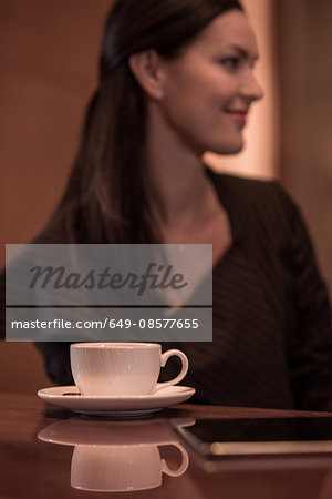 Businesswoman sitting at hotel bar with coffee and  digital tablet