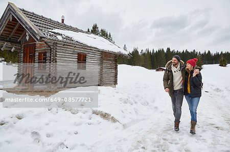 Couple hiking from log cabin in winter, Elmau, Bavaria, Germany